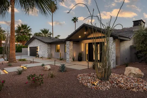 a front view of a house with a tree
