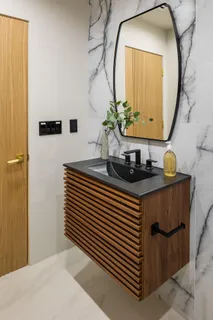a bathroom with a sink a mirror and a potted plant