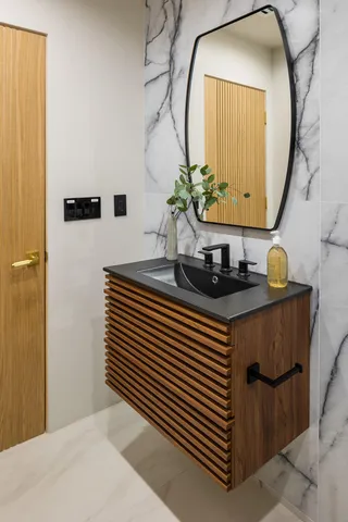 a bathroom with a sink a mirror and a potted plant