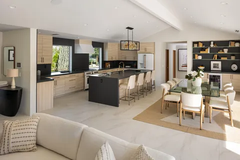 a living room with furniture a rug and kitchen view
