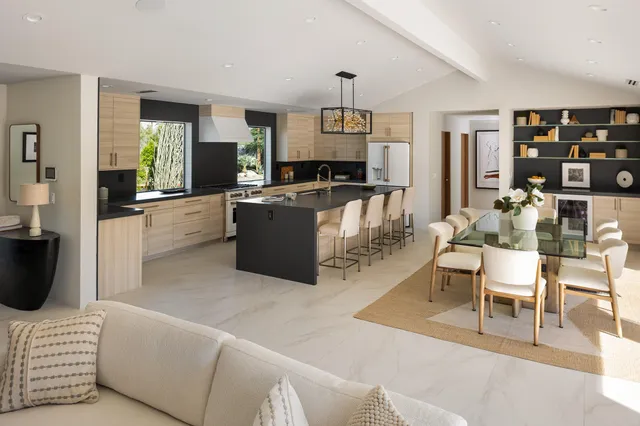 a living room with furniture a rug and kitchen view