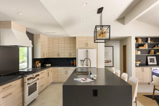 a kitchen with stainless steel appliances a sink dishwasher a stove a microwave oven with white cabinets and wooden floor