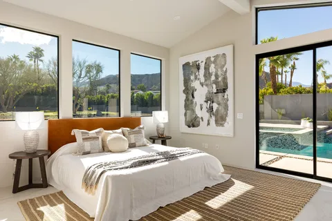 a bedroom with a large window and a bed