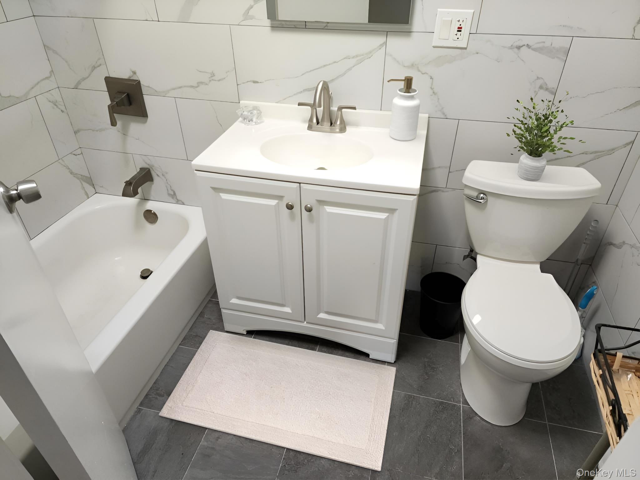 45-01 Ditmars Boulevard, Unit 2R Queens, NY 11105 - Photo 12 of 13 a white toilet sitting next to a white sink