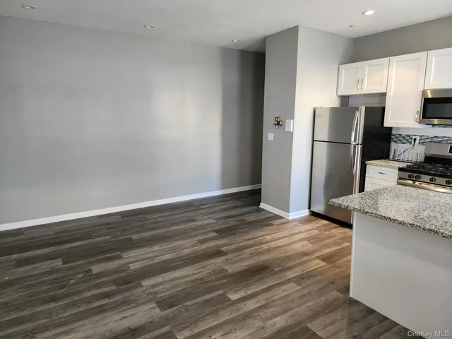 a view of a kitchen with wooden floor and electronic appliances