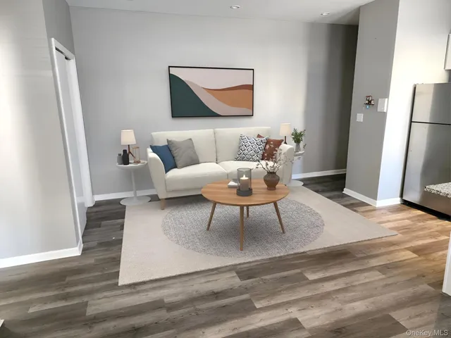 a living room with furniture a refrigerator and a table