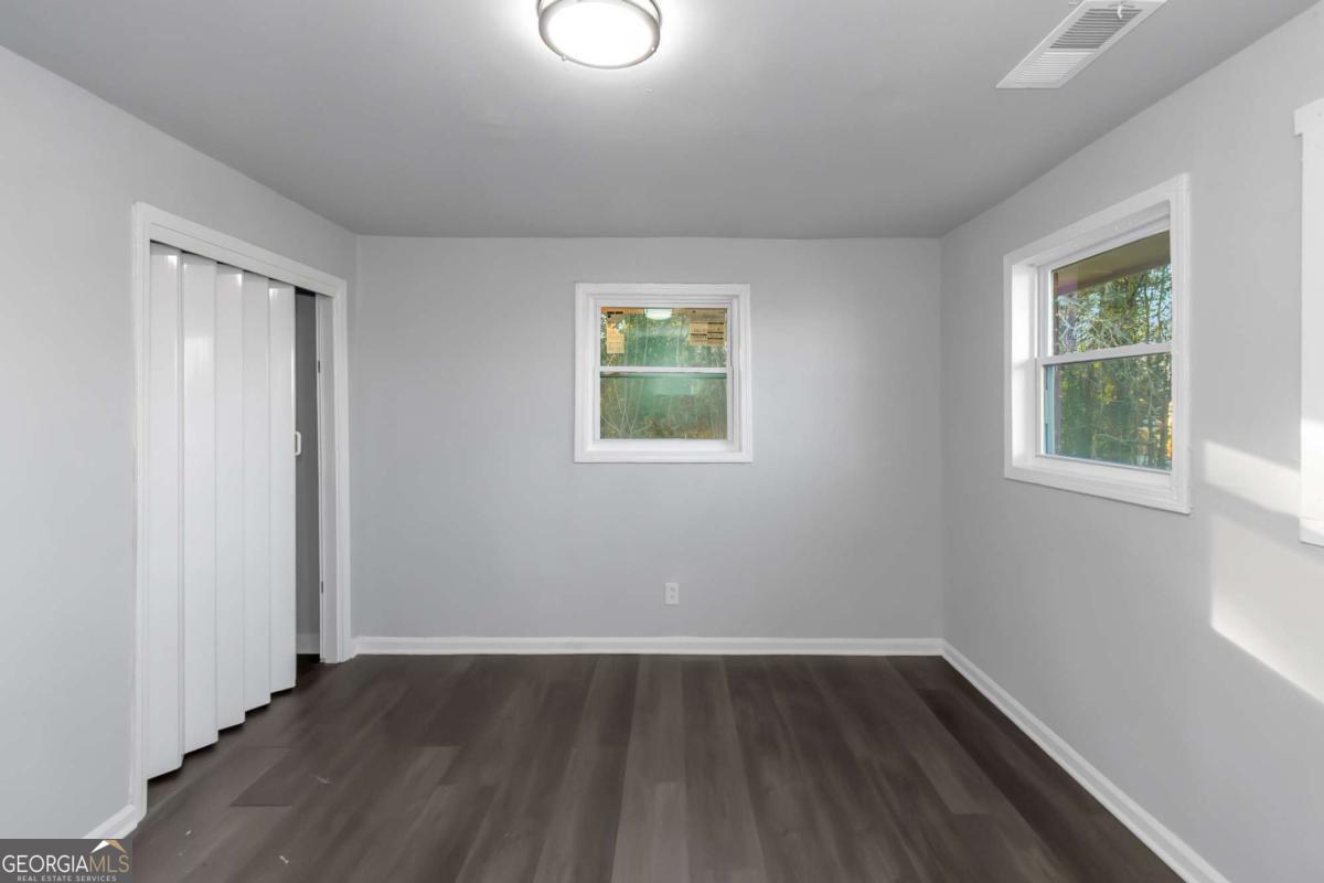 1829 Joy Lake Road Morrow, GA 30260 - Photo 20 of 26 an empty room with wooden floor and windows