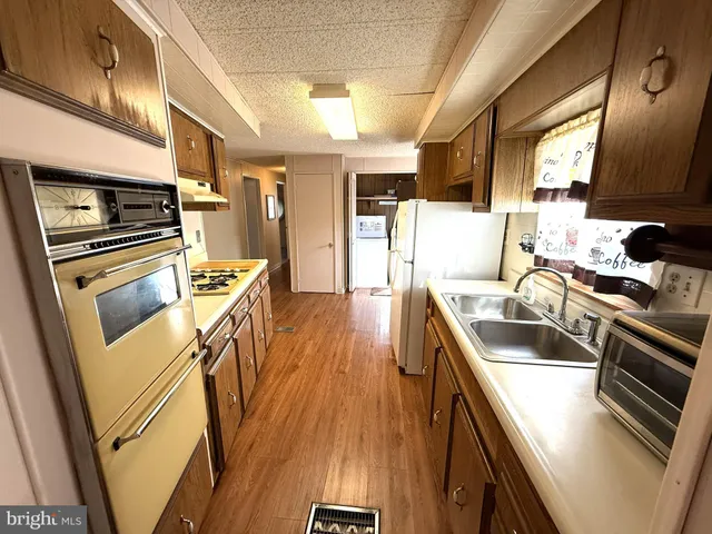 a kitchen with stainless steel appliances granite countertop a stove a sink dishwasher and a refrigerator