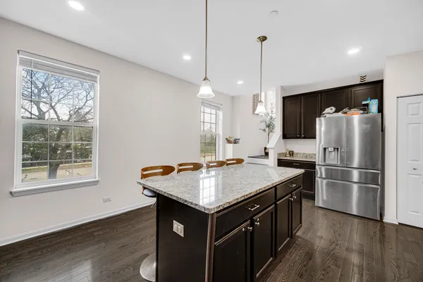 a kitchen with a stove a refrigerator a sink dishwasher with a dining table and chairs