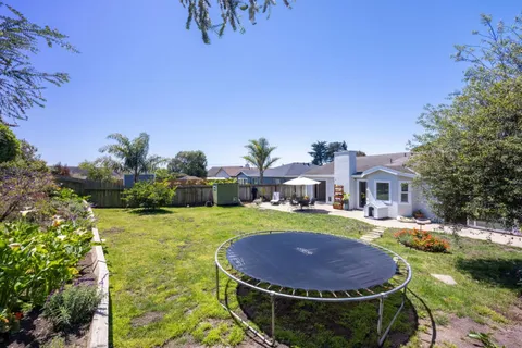 a view of a house with a swimming pool and a yard