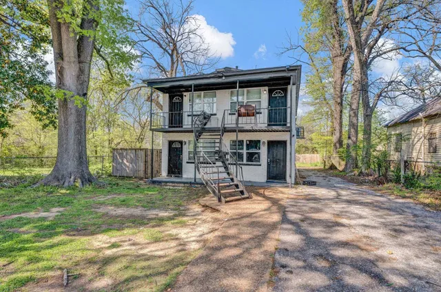 a view of a house with a yard and tree