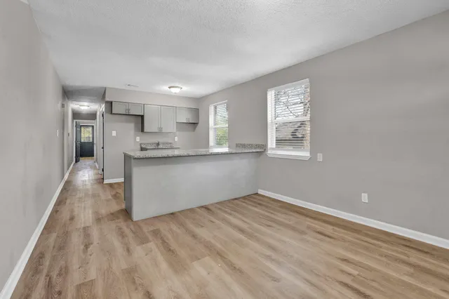 a view of a kitchen with wooden floor and a window