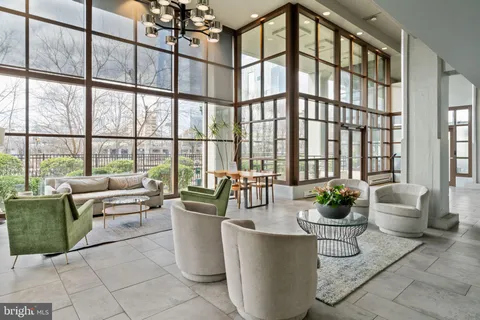 a living room with furniture and potted plants
