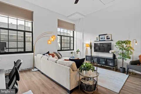 a living room with furniture a flat screen tv and a floor to ceiling window