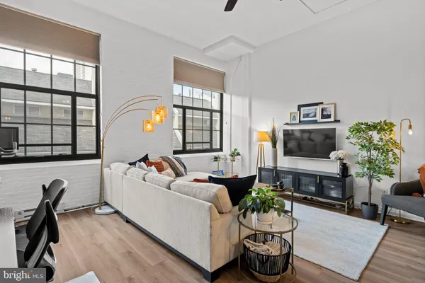 a living room with furniture a flat screen tv and a floor to ceiling window