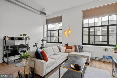 a living room with furniture and floor to ceiling windows