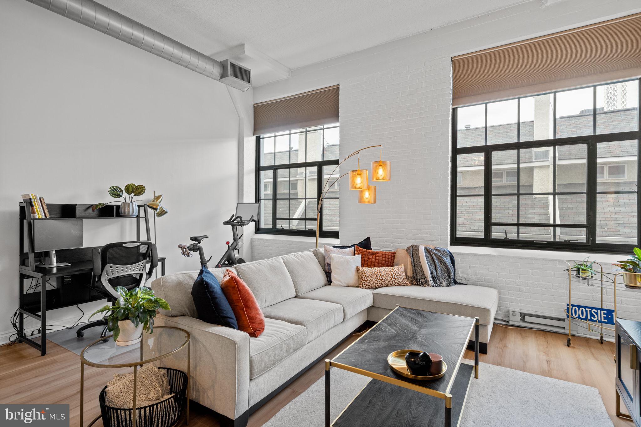 2429 Locust Street, Unit 314 Philadelphia, PA 19103 - Photo 7 of 21 a living room with furniture and floor to ceiling windows
