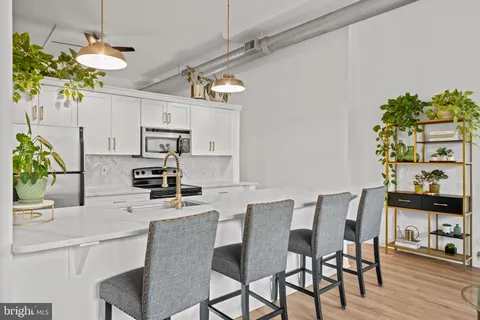 a kitchen with stainless steel appliances kitchen island granite countertop a table and chairs in it