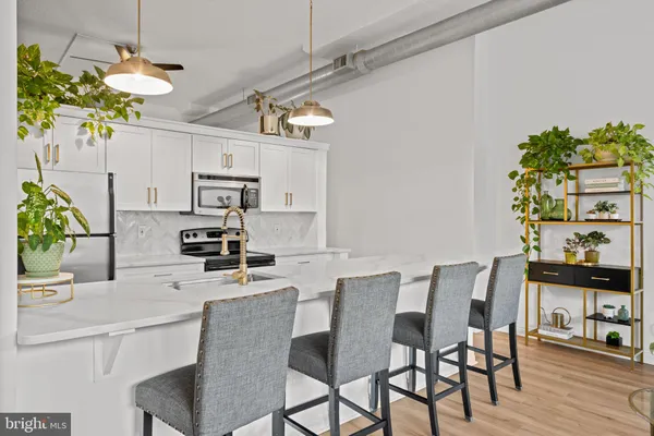 a kitchen with stainless steel appliances kitchen island granite countertop a table and chairs in it
