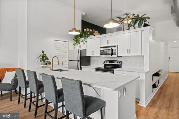 a kitchen with cabinets appliances and a dining table