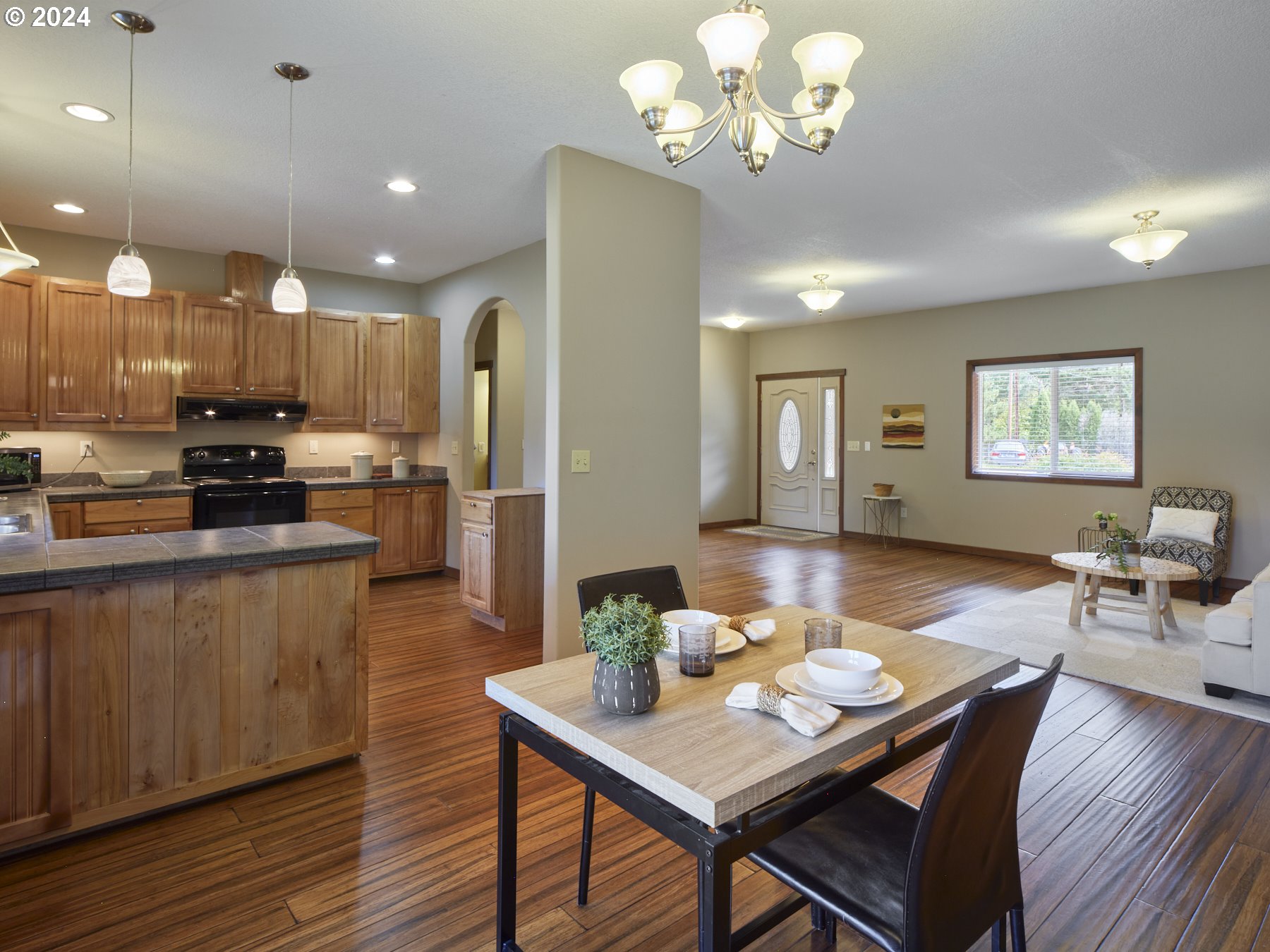 29902 Northwest 51st Avenue Ridgefield, WA 98642 - Photo 11 of 46 a view of a dining room with furniture a kitchen and chandelier