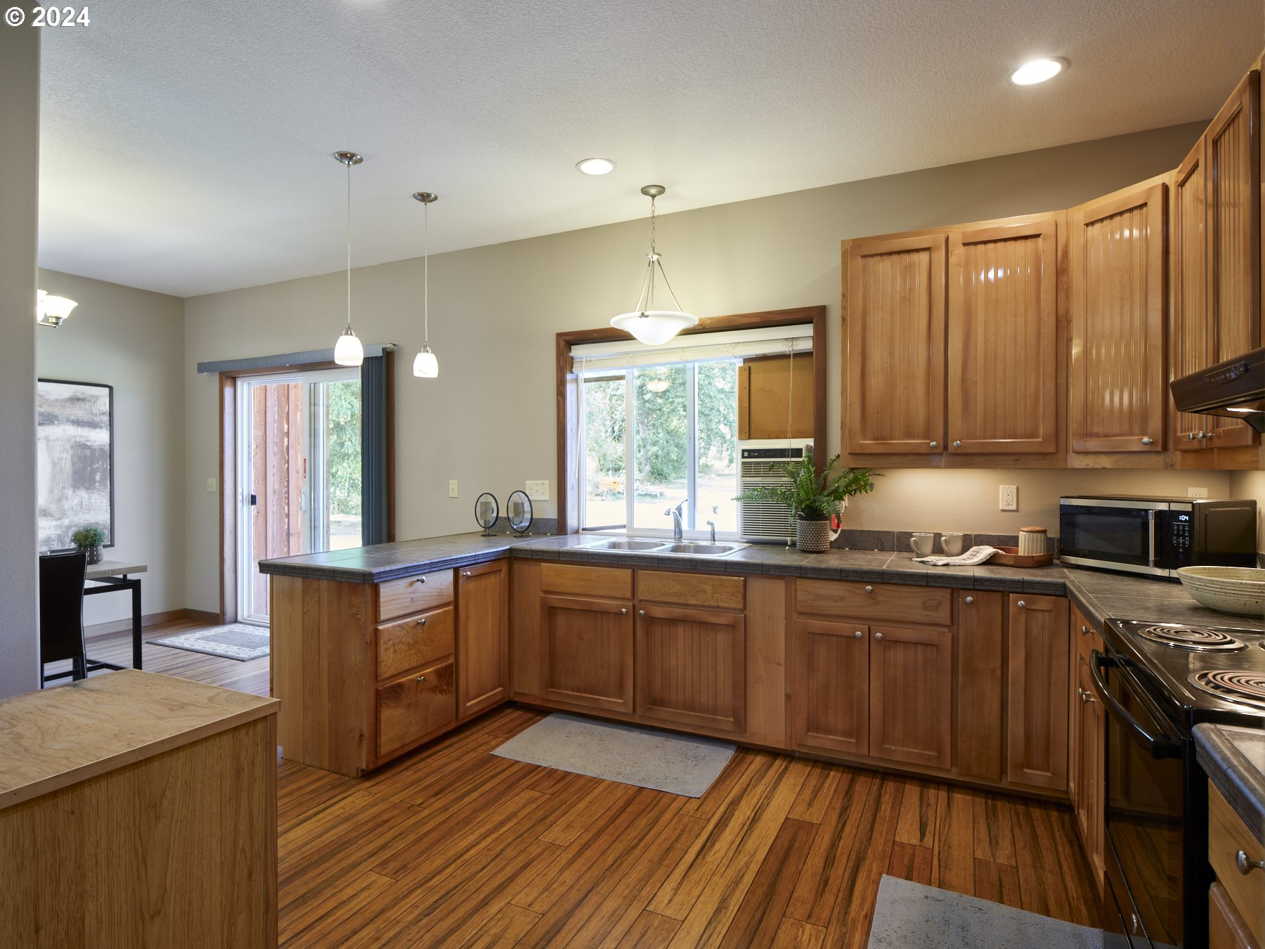 29902 Northwest 51st Avenue Ridgefield, WA 98642 - Photo 13 of 46 a large kitchen with stainless steel appliances granite countertop a stove top oven a sink dishwasher and white cabinets with wooden floor