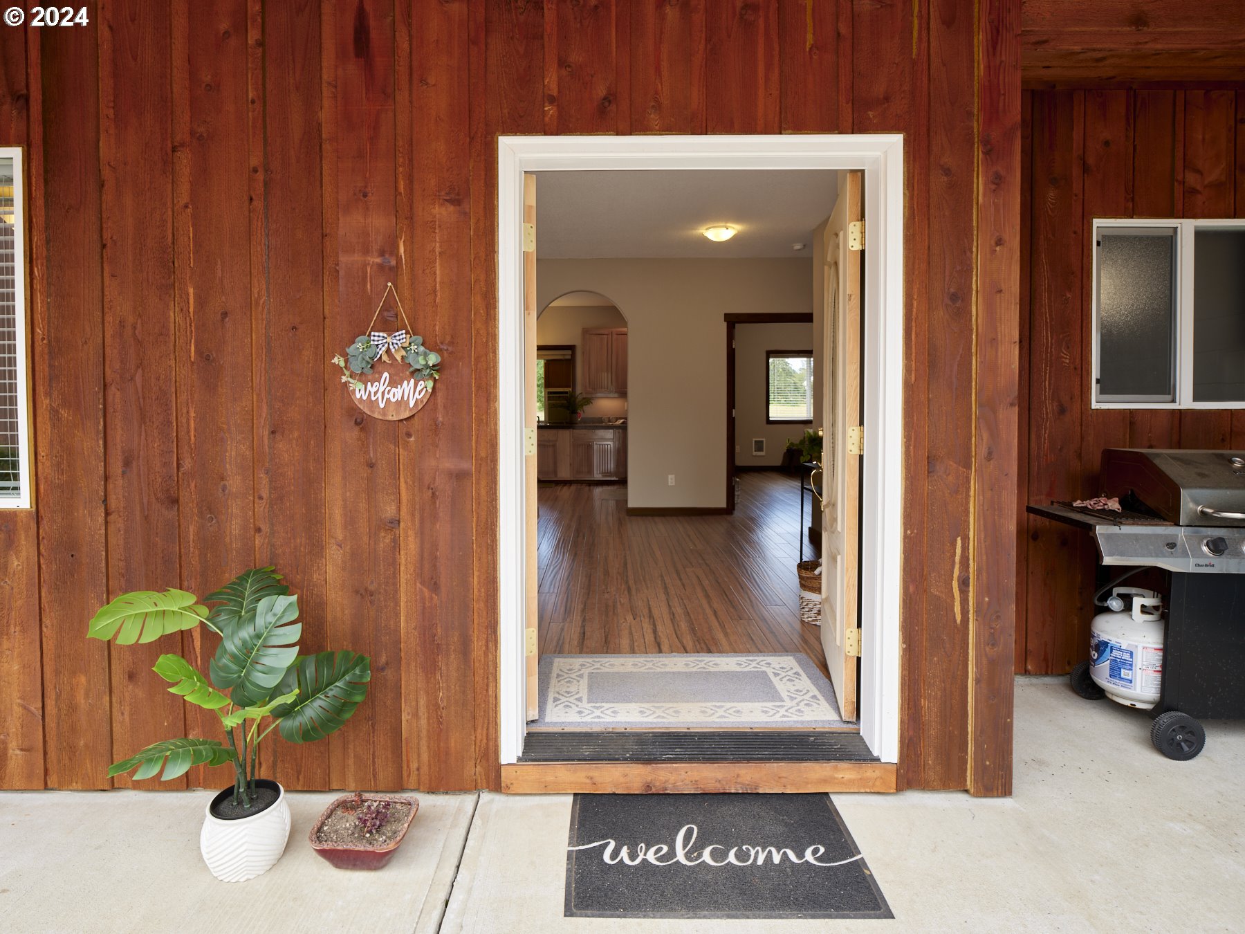 29902 Northwest 51st Avenue Ridgefield, WA 98642 - Photo 5 of 46 a view of a hallway with wooden floor and a potted plant