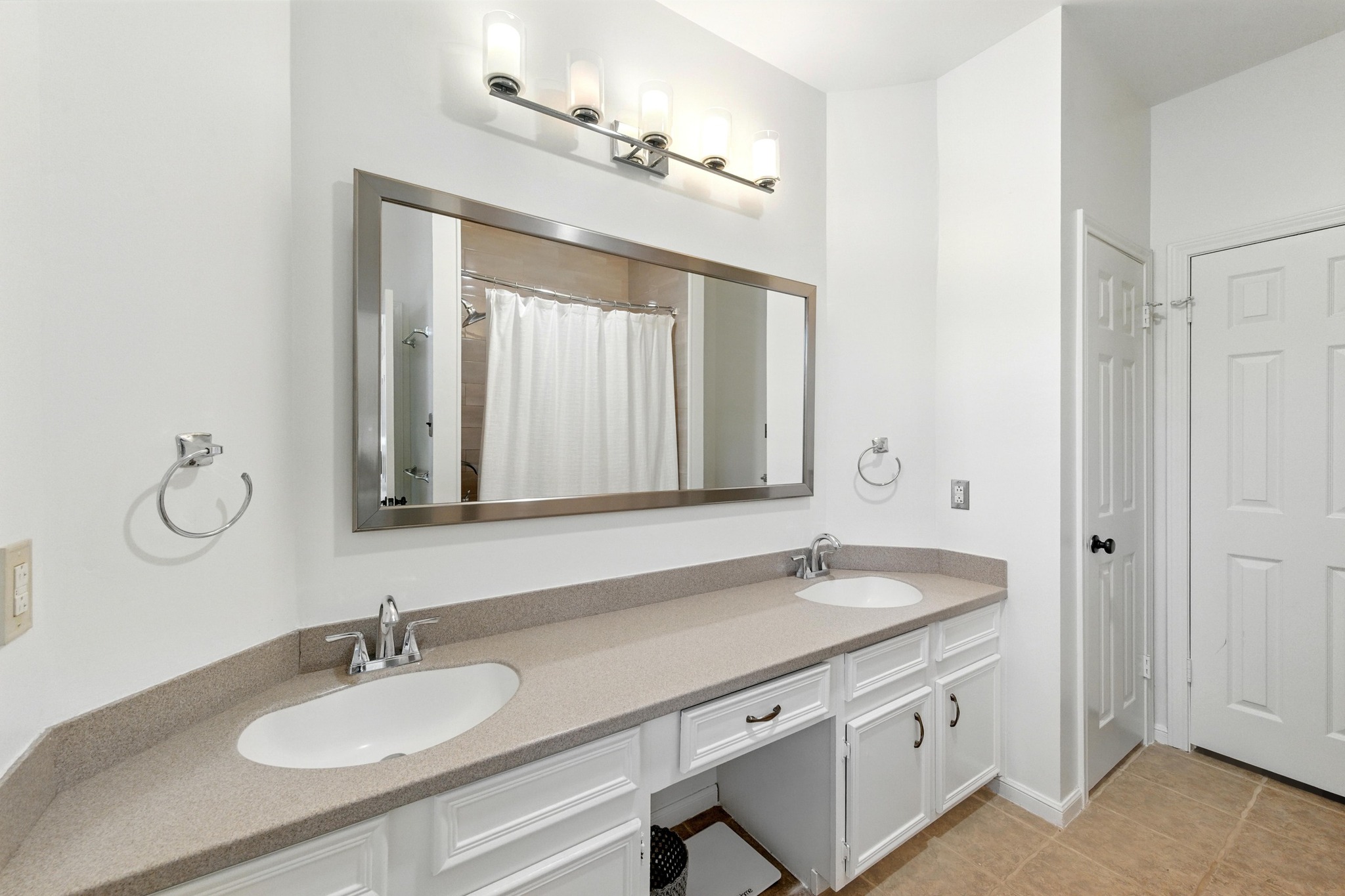 5807 Convict Hill Road Austin, TX 78749 - Photo 18 of 27 Dual sinks, updated lighting, and a large mirror offer everyday ease in the bright and functional primary bathroom.
