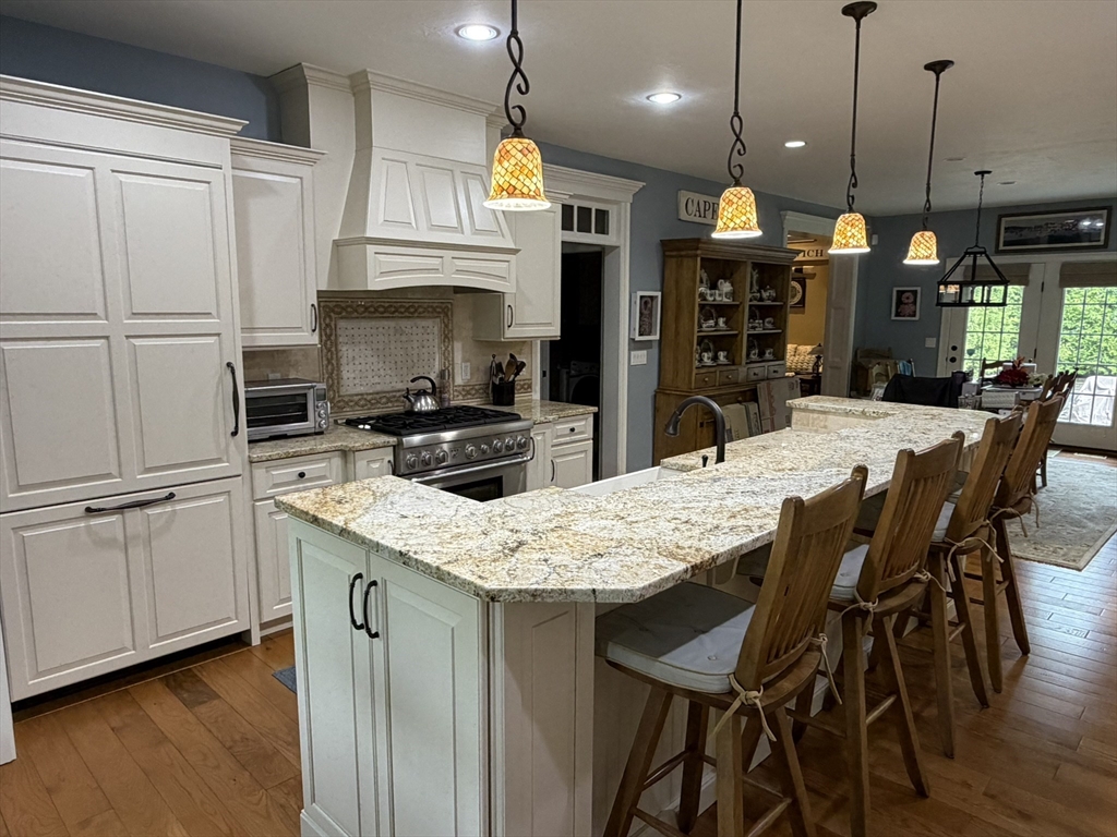 4 Tamarack Lane Sandwich, MA 02563 - Photo 10 of 42 a kitchen with stainless steel appliances kitchen island granite countertop a table chairs sink and cabinets