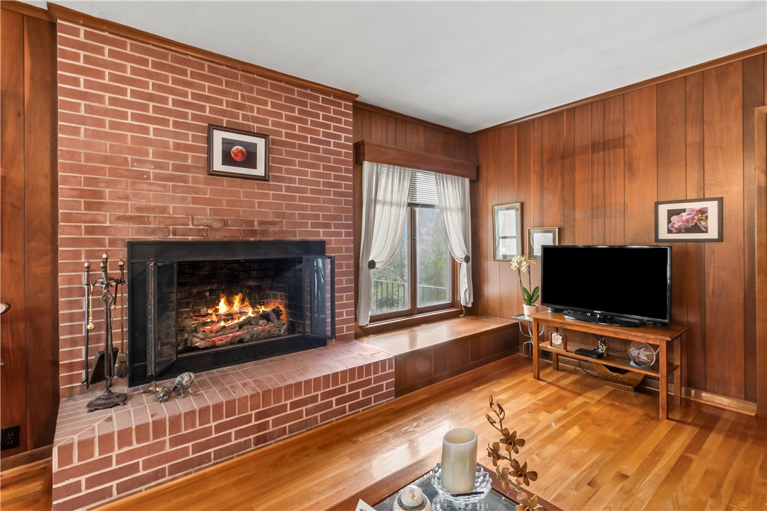 118 Blair Road Belton, SC 29627 - Photo 27 of 49 Rich wood paneling complements a robust brick fireplace under warm hardwood flooring.