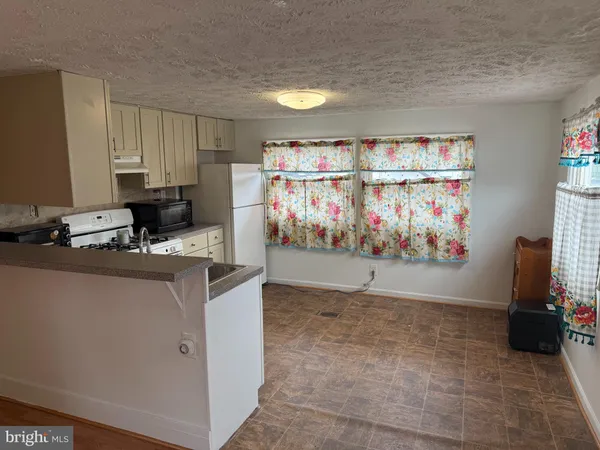 a room with kitchen island a stove a sink and a refrigerator