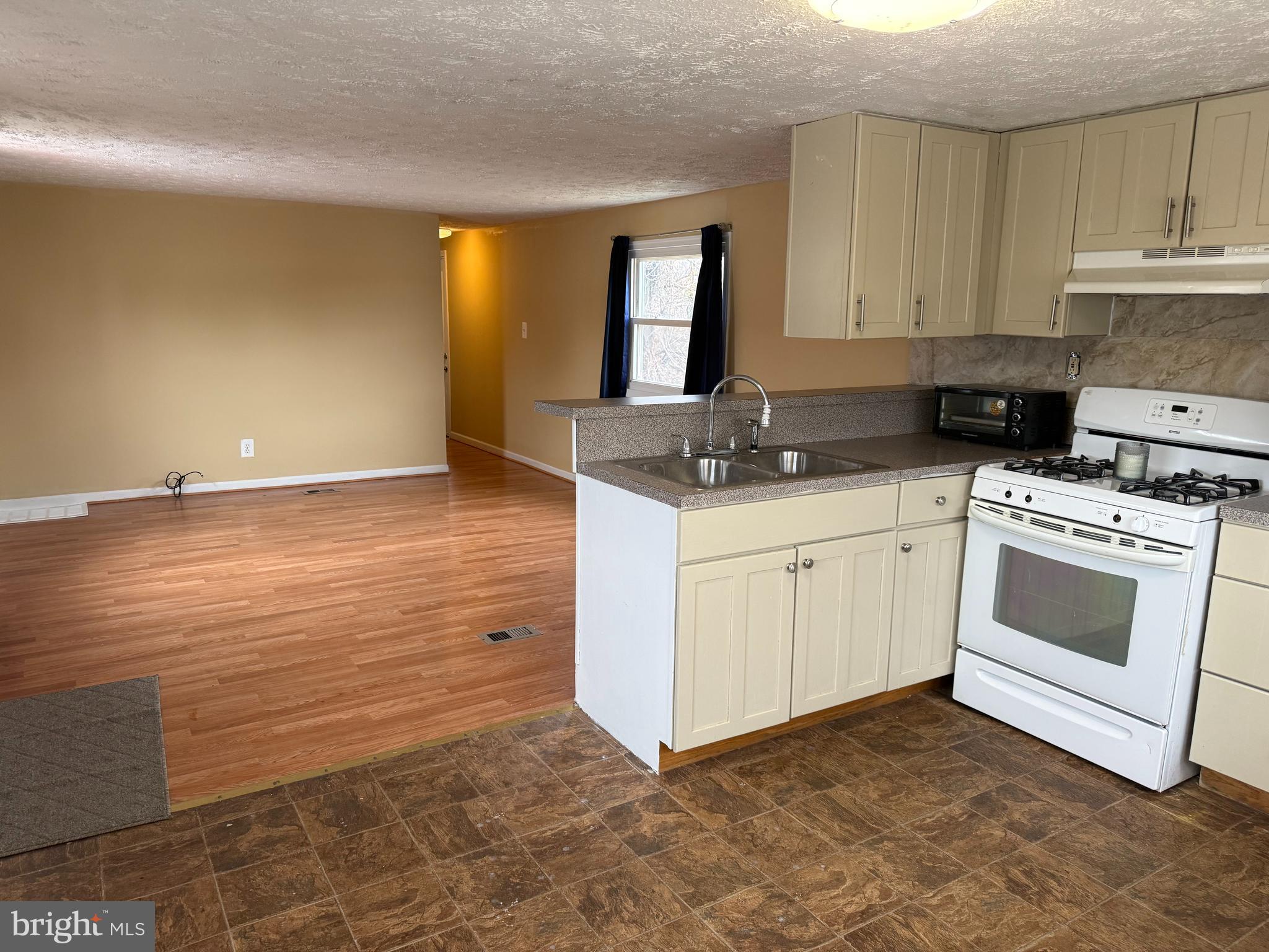 478 Mirabile Lane Baltimore, MD 21224 - Photo 9 of 23 a kitchen with granite countertop white cabinets and white appliances