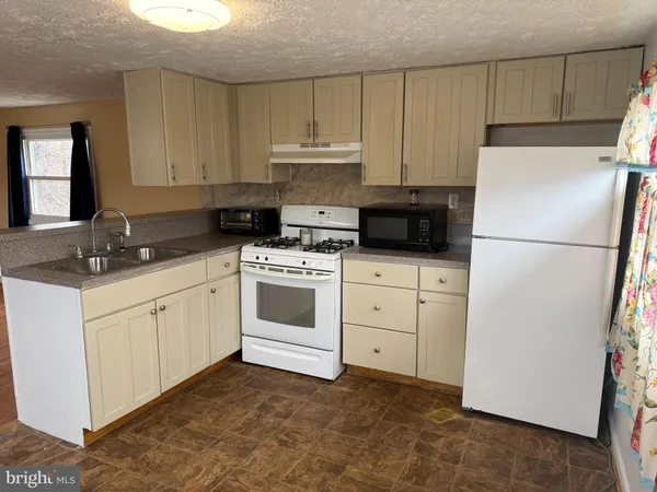 a kitchen with appliances a sink and cabinets