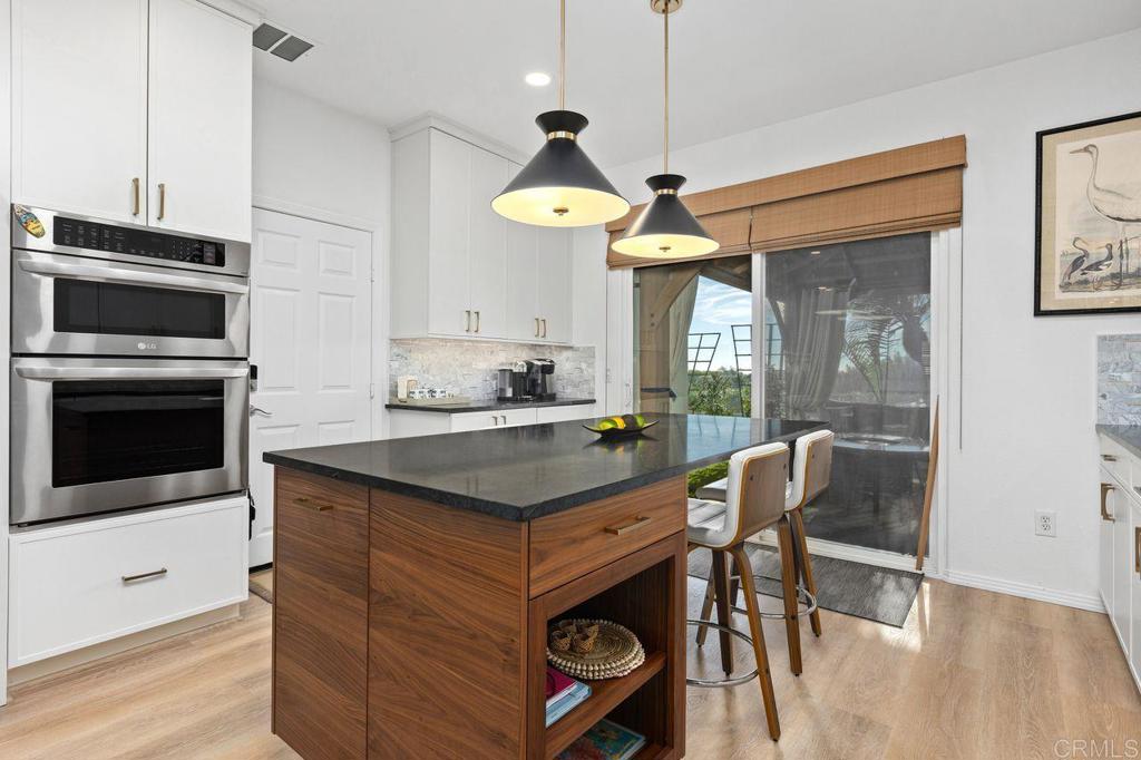 7039 Whitewater Street Carlsbad, CA 92011 - Photo 12 of 65 a kitchen with a stove a chandelier and a refrigerator