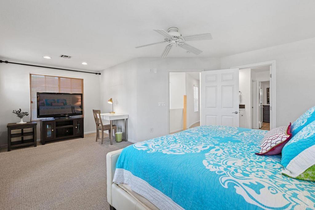 7039 Whitewater Street Carlsbad, CA 92011 - Photo 16 of 65 a bedroom with a bed and a flat screen tv