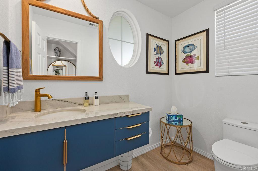 7039 Whitewater Street Carlsbad, CA 92011 - Photo 6 of 65 a bathroom with a toilet a sink and mirror