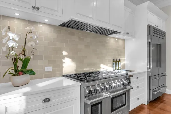 a kitchen with a stove a faucet cabinets and stainless steel appliances