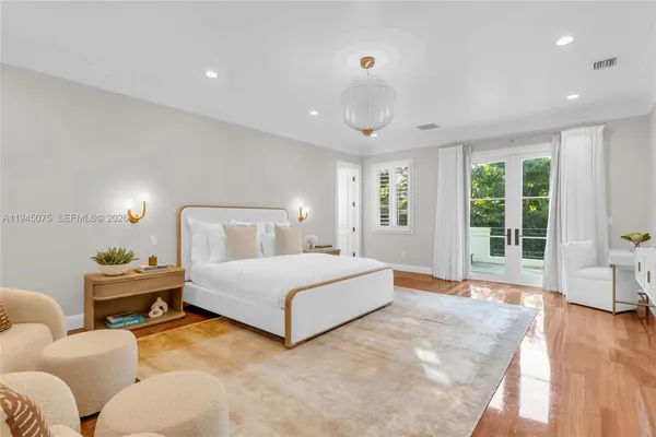 a spacious bedroom with a bed a couch and large window