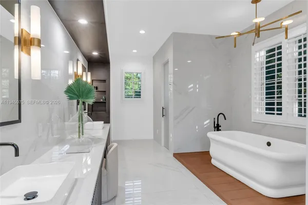 a bathroom with a tub sink and mirror