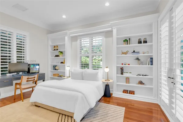 a bedroom with a bed a table and a large window