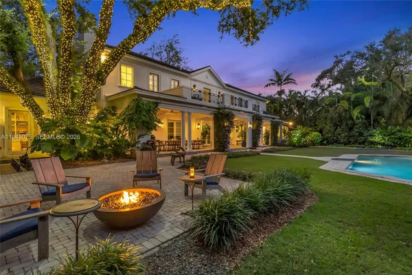 a view of a house with backyard and sitting area
