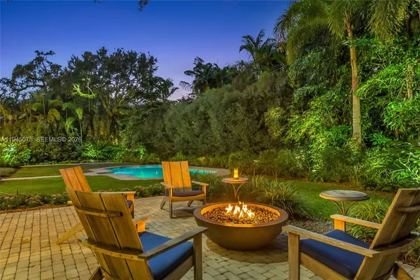 a view of a patio with couches table and chairs potted plants and a palm tree