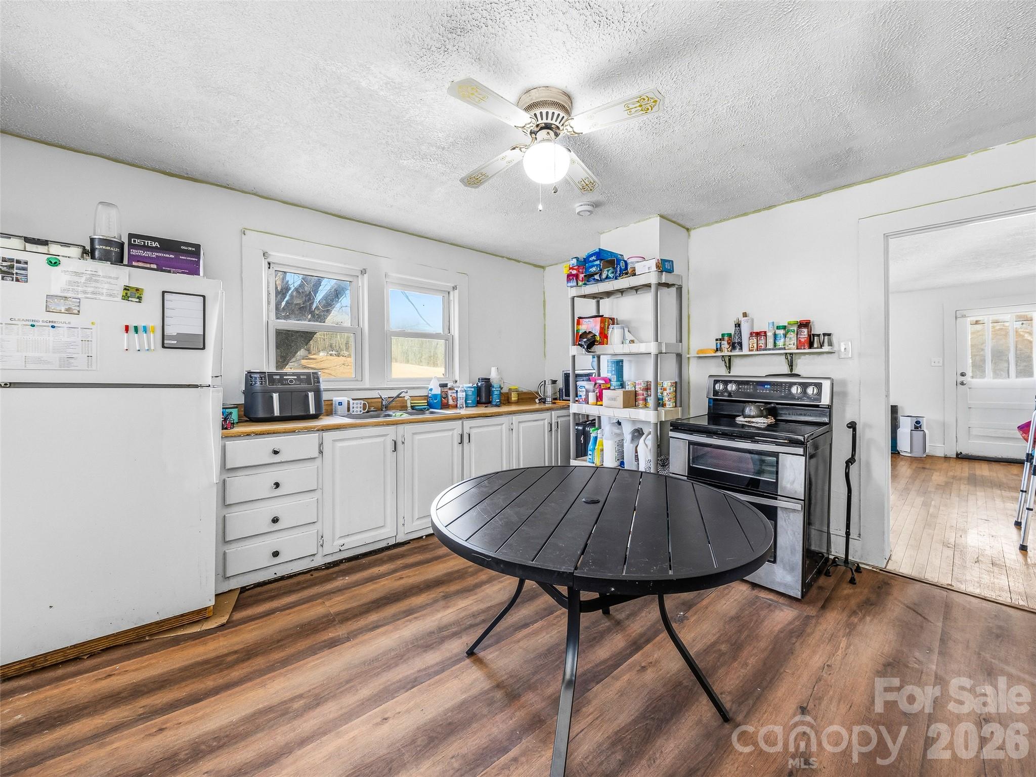 800 Murray Road Canton, NC 28716 - Photo 4 of 15 a kitchen with stainless steel appliances granite countertop a refrigerator a stove and white cabinets with wooden floor