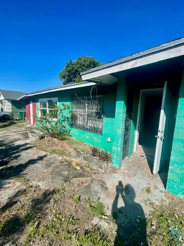 a front view of a house with a yard and potted plants