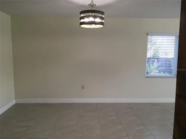 an empty room with windows and ceiling fan