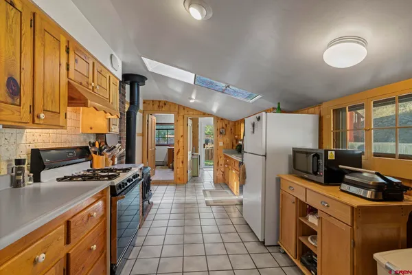 a kitchen with refrigerator a stove a sink dishwasher and wooden cabinets with wooden floor