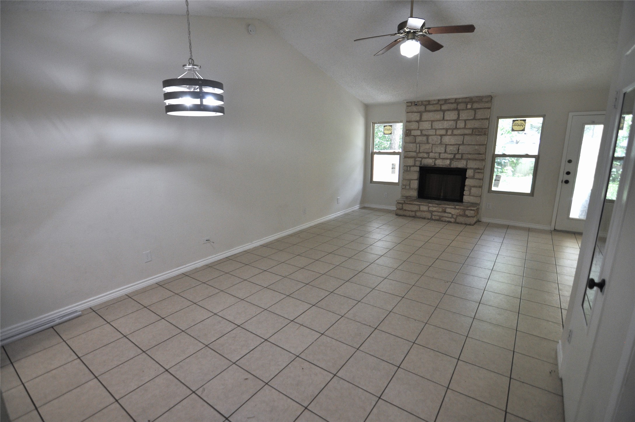 8809 Piney Point Drive, Unit B Austin, TX 78729 - Photo 4 of 10 A generous living area presents high ceilings and a stone-faced fireplace, ready for cozy gatherings.
