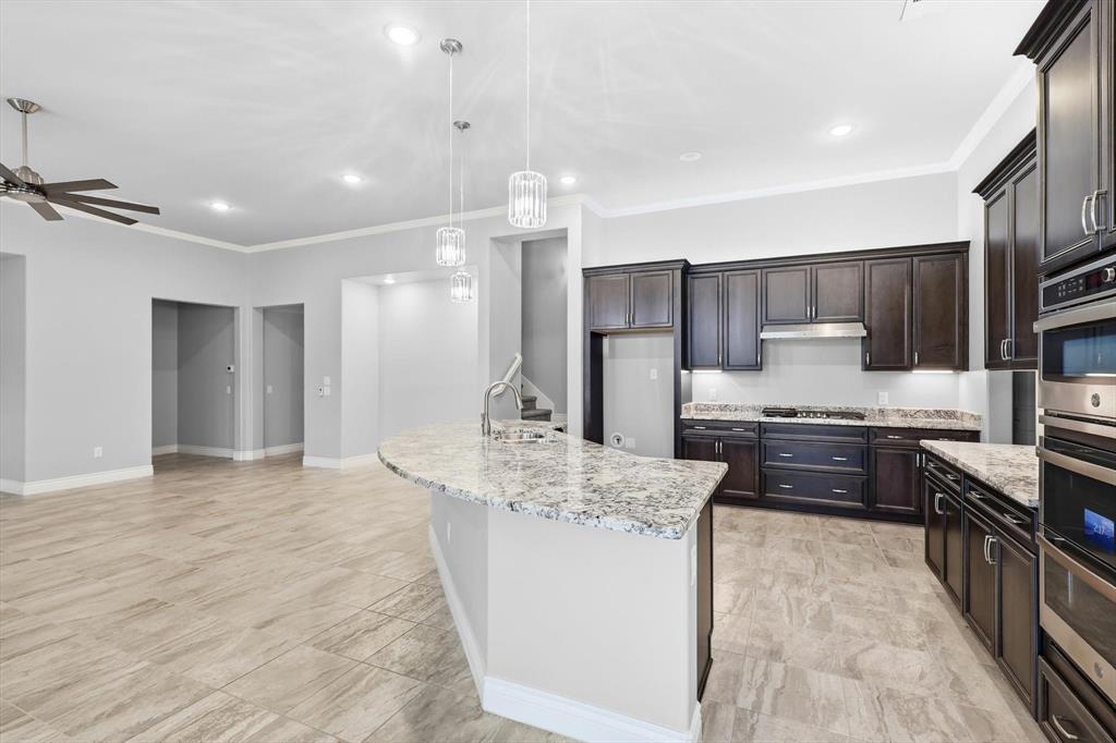 8813 Basanite Avenue Denton, TX 76207 - Photo 11 of 40 a large kitchen with kitchen island a sink stainless steel appliances and cabinets