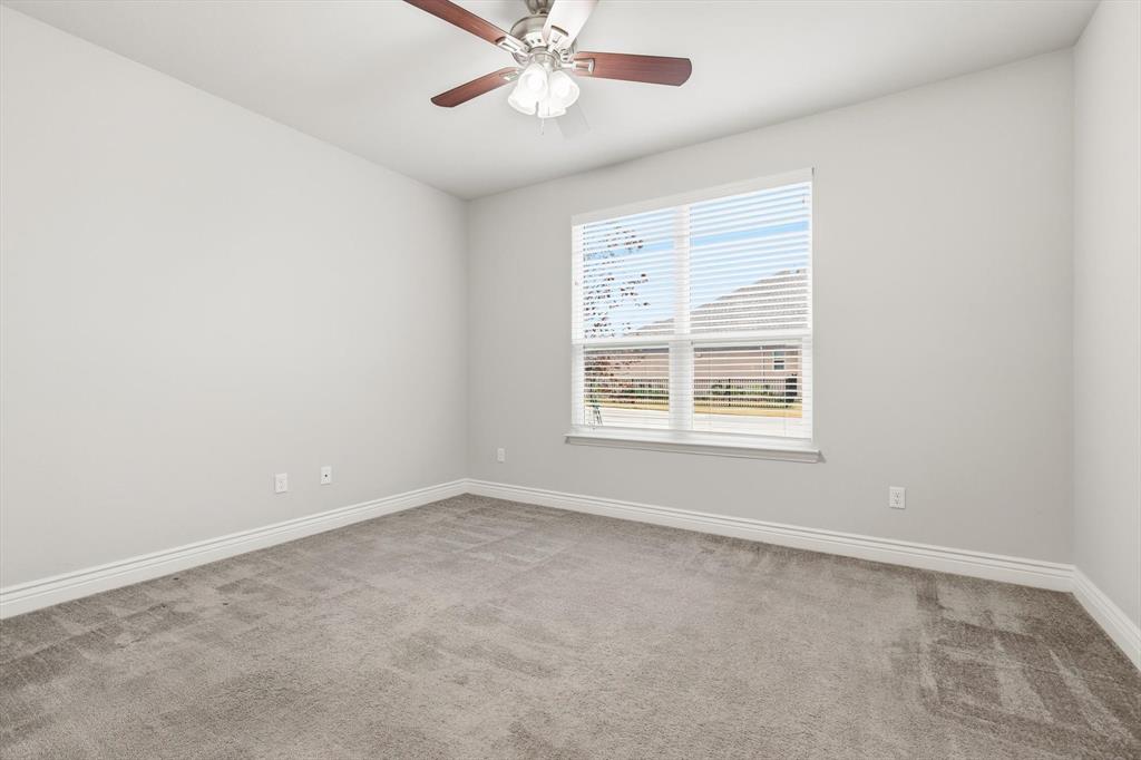 8813 Basanite Avenue Denton, TX 76207 - Photo 23 of 40 an empty room with a window and a fan