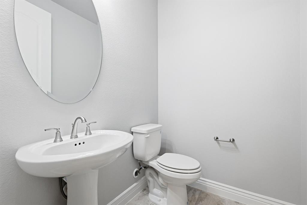 8813 Basanite Avenue Denton, TX 76207 - Photo 25 of 40 a bathroom with a sink a mirror and toilet